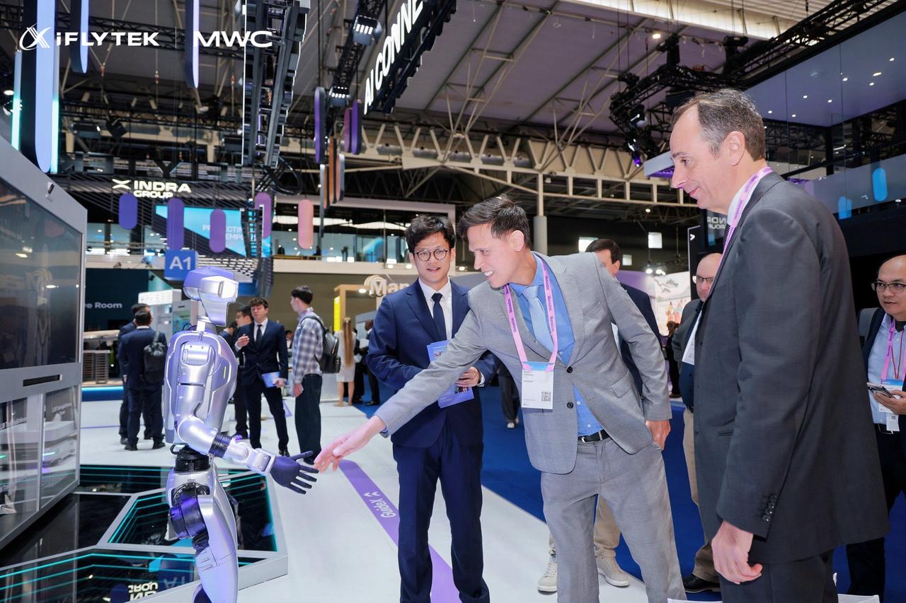 Visitors interact with an iFLYTEK robotic demonstration at MWC26