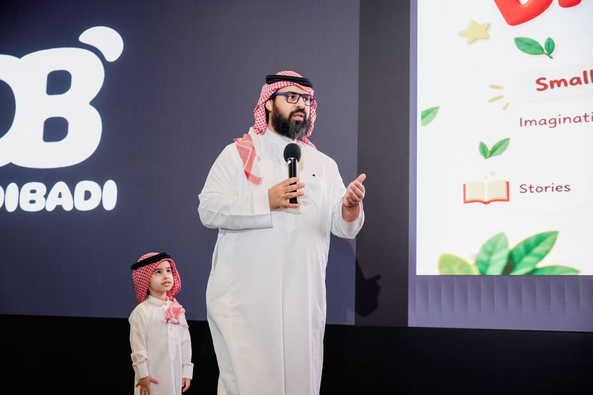 Speaker presenting Dadibadi Pod on stage with a child at launch event